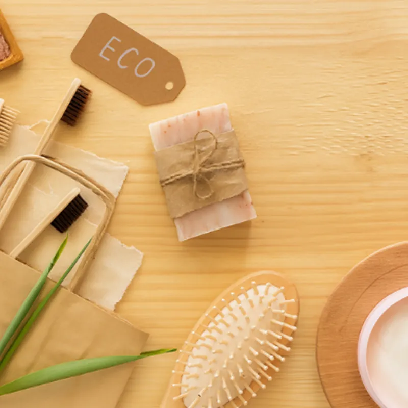 Eco-friendly toiletries and bamboo brush on a wooden surface